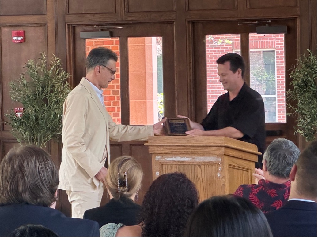 One man presenting a plaque to another man