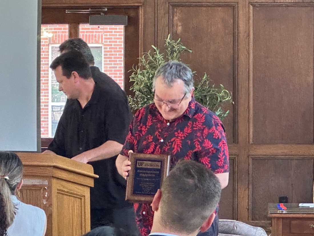 One man presenting a plaque to another man
