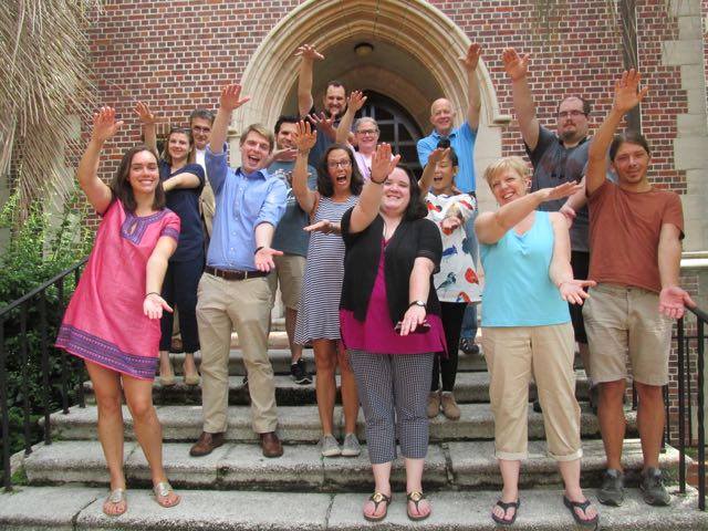 Students and Faculty doing the Gator Chomp and smiling.